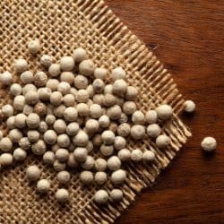 Macro close-up of Organic White peppercorns (Piper nigrum) on the wooden top background and jute mat, When To Use White Pepper?