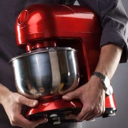 Man holding red food processor on a gray background, How Big Should My Food Processor Be?