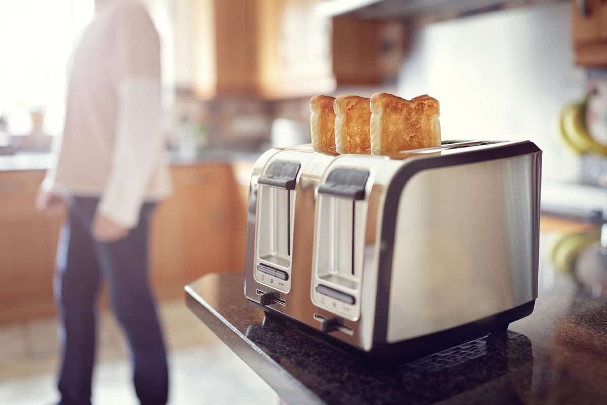 Man in the kitchen preparing toast for breakfast