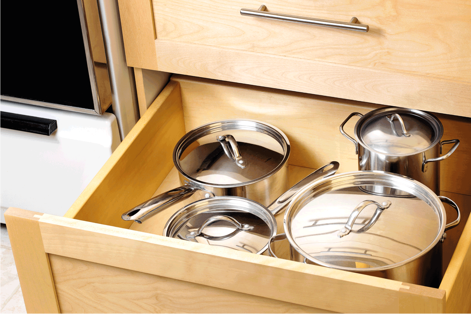 Organized kitchen drawer with stainless steel pots and pans