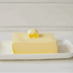Piece of butter on a wooden desk. How To Soften Butter For Spreading