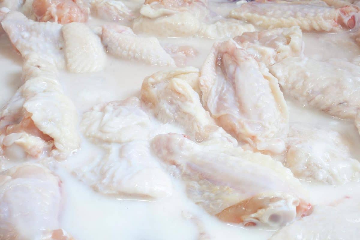 Raw chicken wings marinating in buttermilk