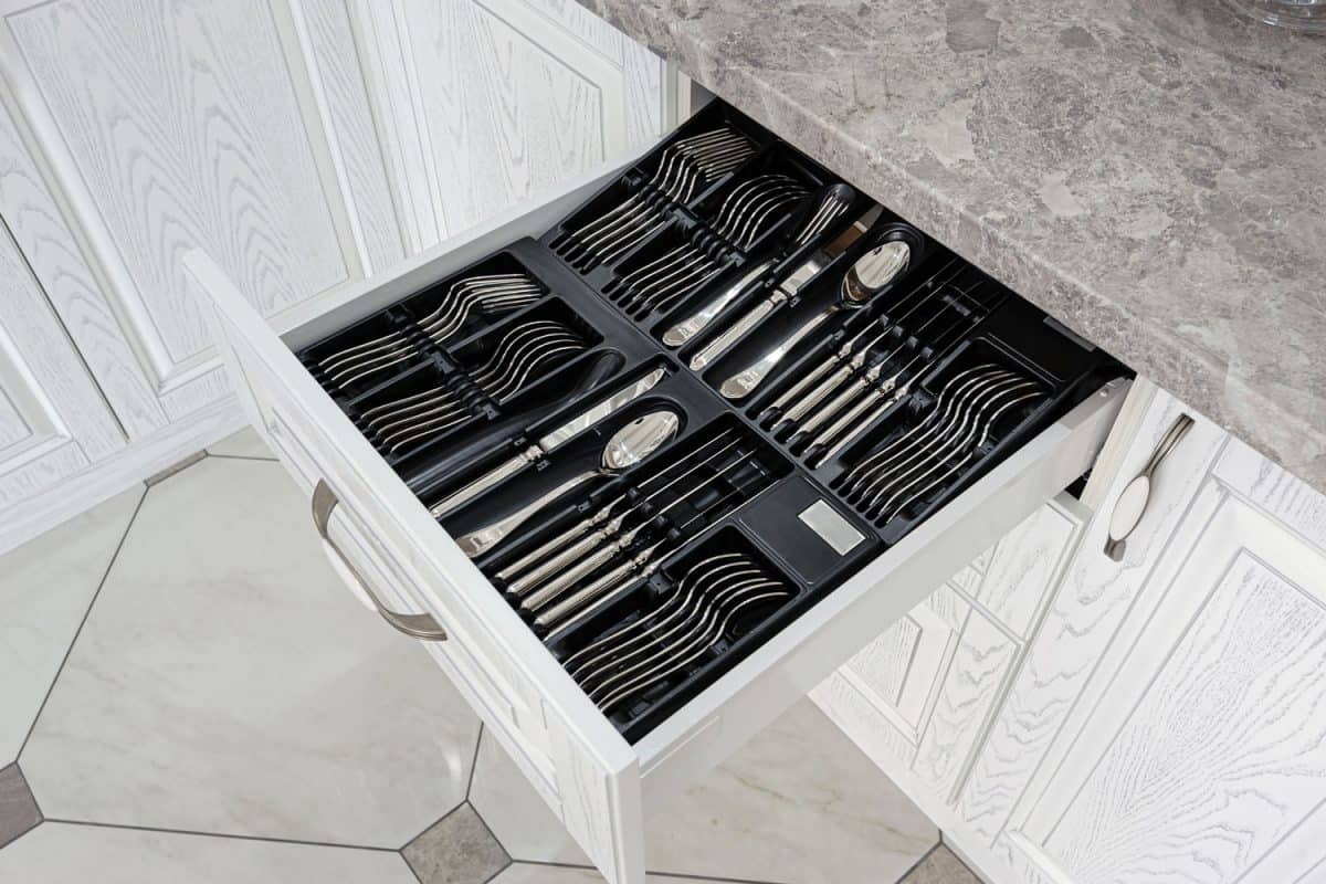 black open drawer with silver cutlery in modern white kitchen, How Much Weight Can Kitchen Drawers Hold?