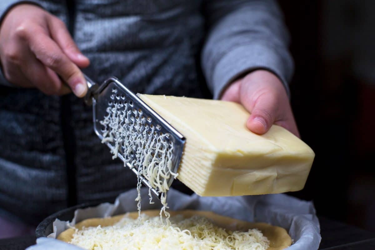 A man grating cheese on the small plate