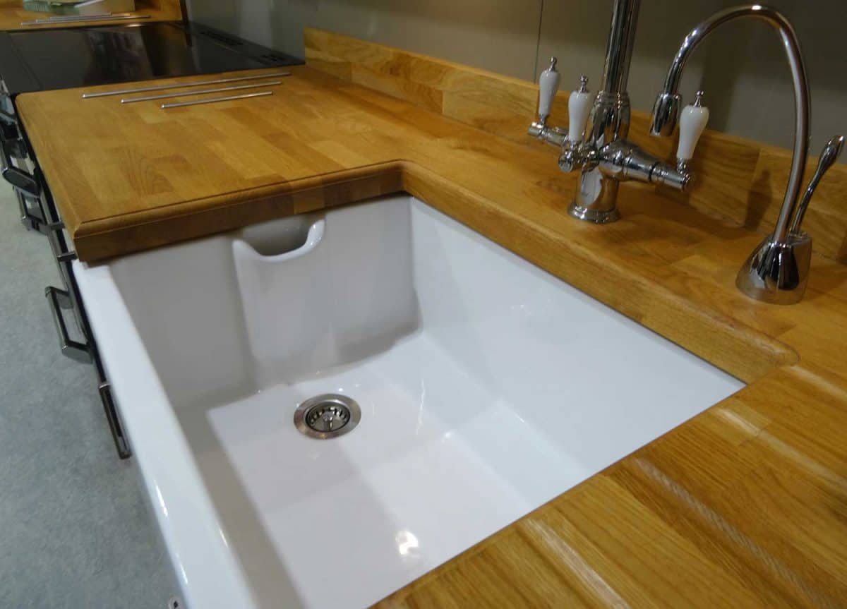 A white ceramic Belfast butler sink with chrome mixed taps