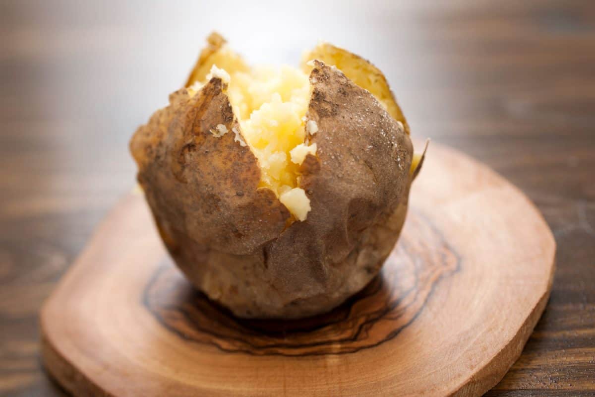 Baked potato on top of a chopping board