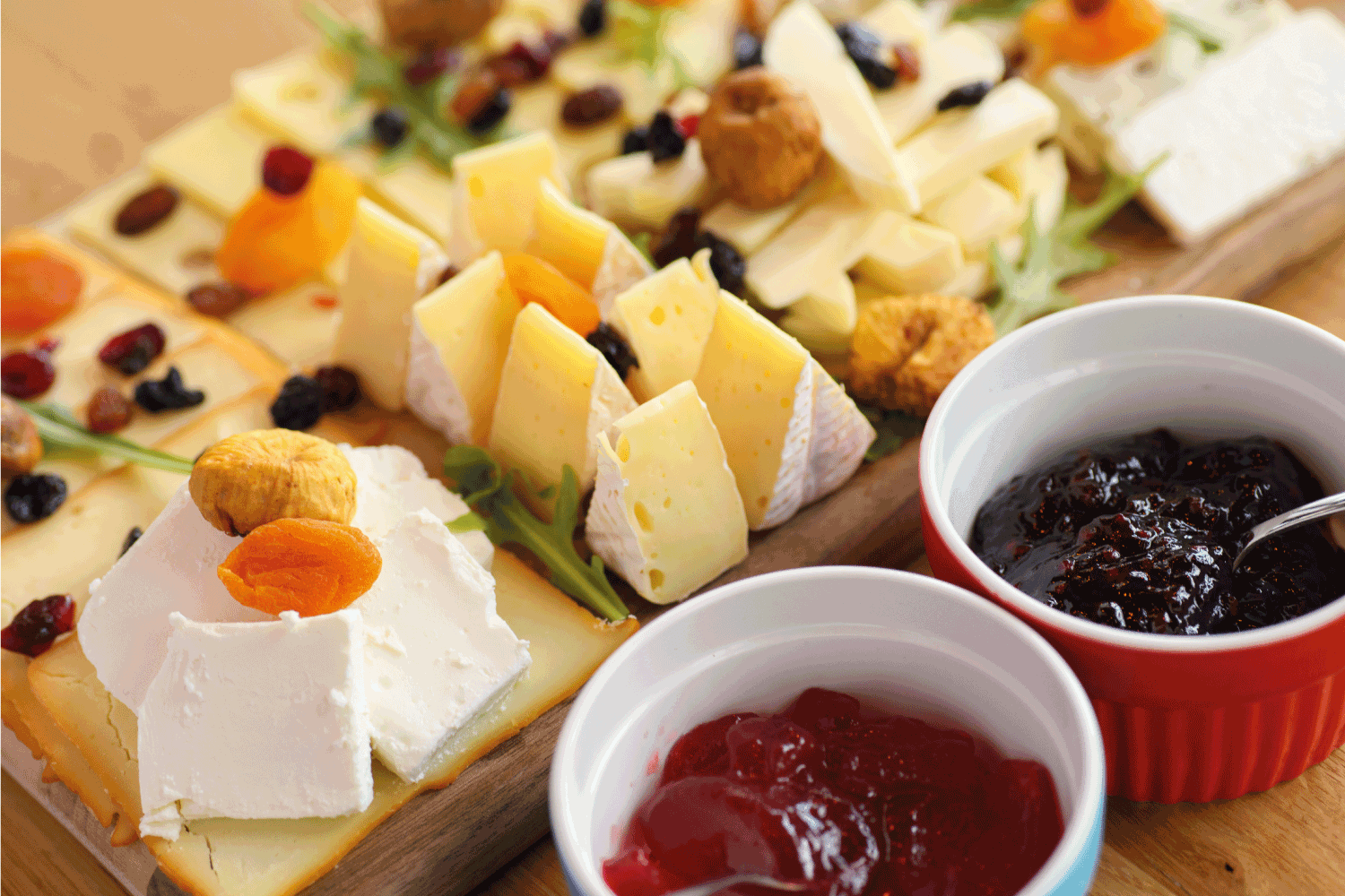 Cheese board with various types cheese, dried fruit and jam
