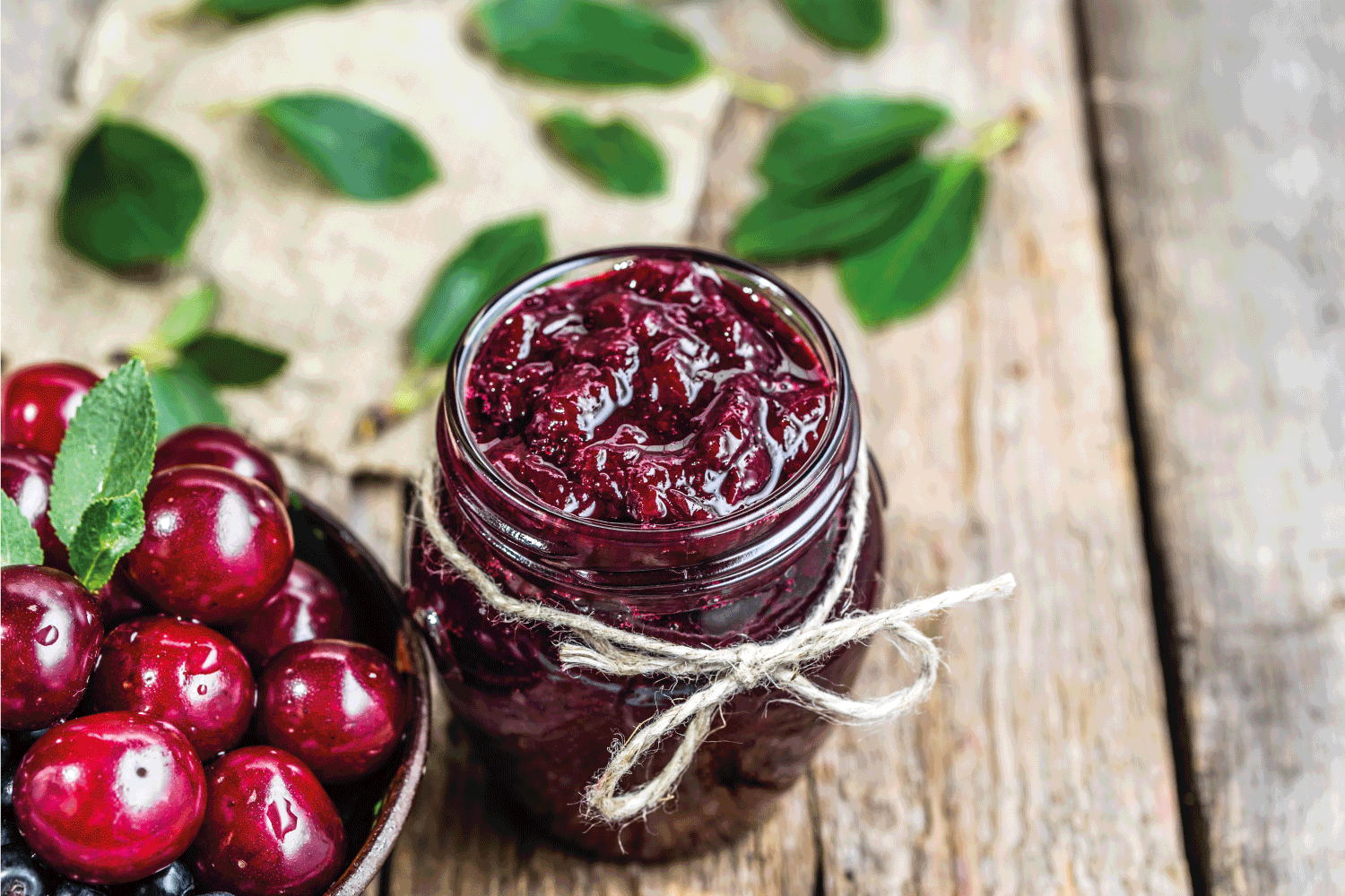 Cherry jam in jar and fresh cherries in a bowl, homemade preserves