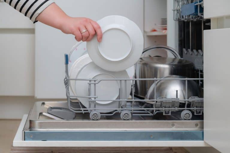 Close up of hand unloading dish washer in the kitchen, How Long Should A Bosch Dishwasher Last?