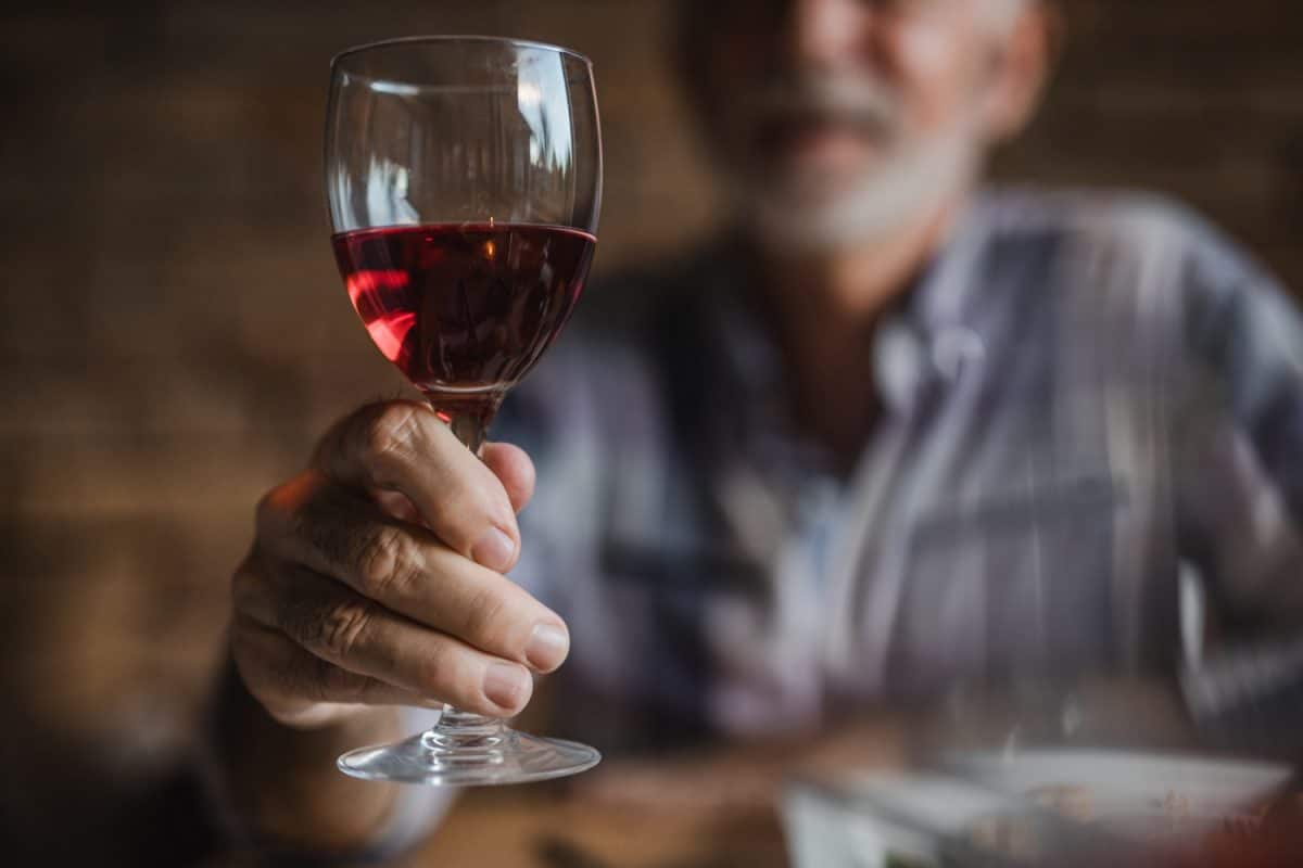 Close up of unrecognizable mature man holding wineglass.