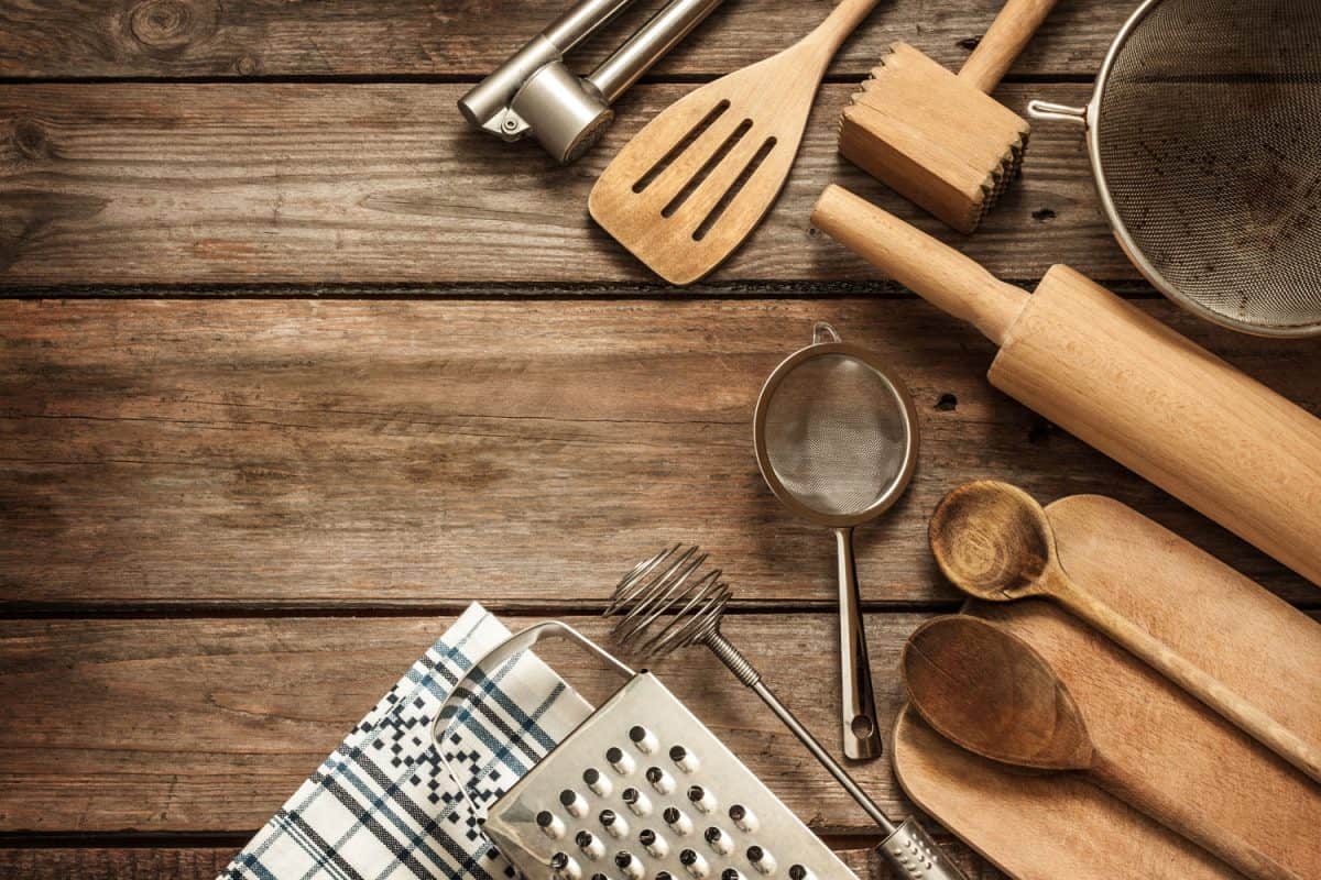 Different kinds of kitchen utensils on the wooden table