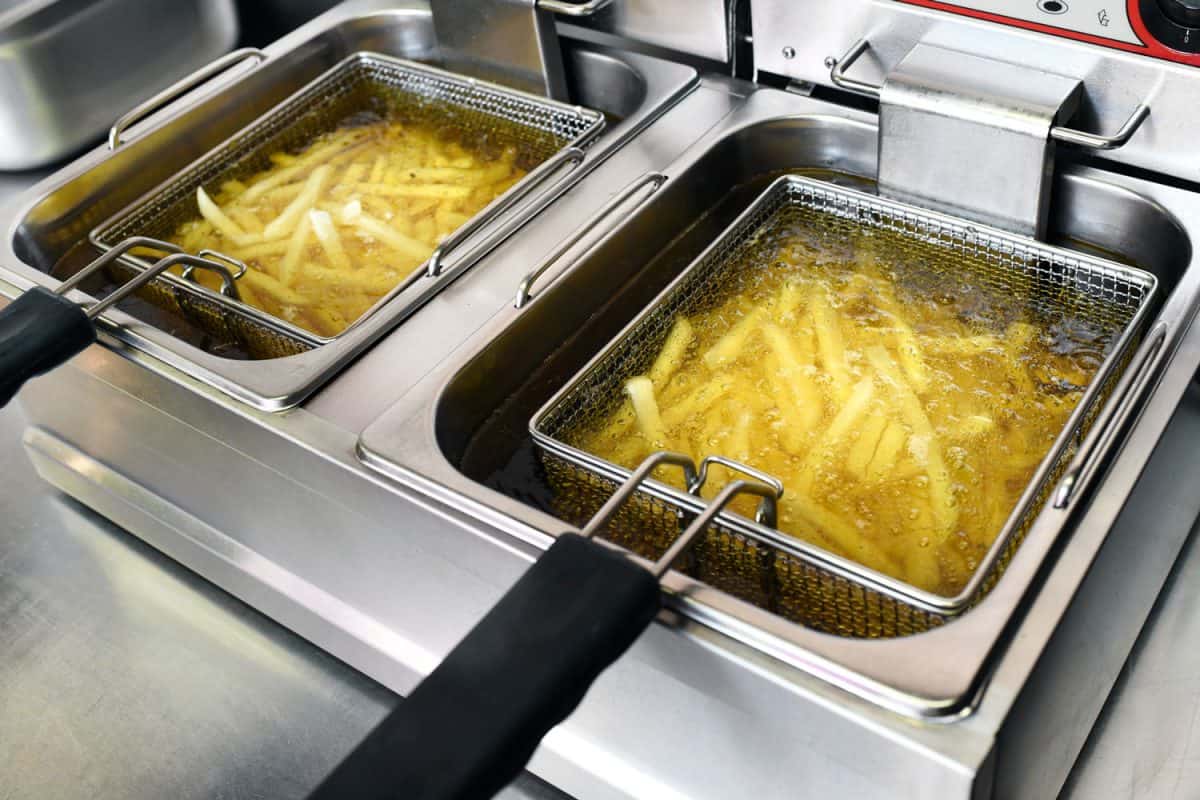French fries or potato chips deep frying in oil in a commercial metal fryer in a restaurant as an accompaniment to meals, How Long To Fry French Fries?