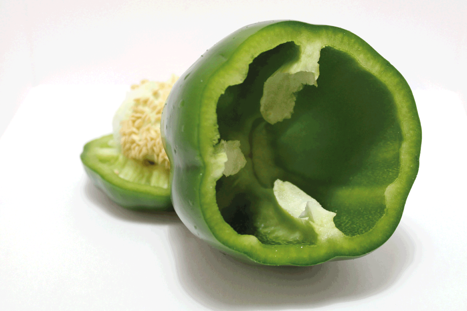 Fresh, washed green pepper with white background - great for recipes that have green peppers - Sliced open, showing inside