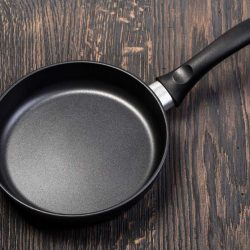 Frying pan on wooden table, Can Frying Pans Go In The Oven?