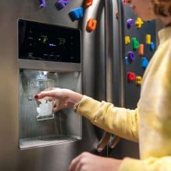 Girl filling glass with ice from Frigidaire Ice maker, How To Reset A Frigidaire Ice Maker