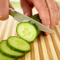 A hand slicing cucumber on cutting board, How To Sharpen A Paring Knife