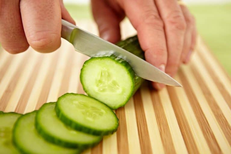 A hand slicing cucumber on cutting board, How To Sharpen A Paring Knife
