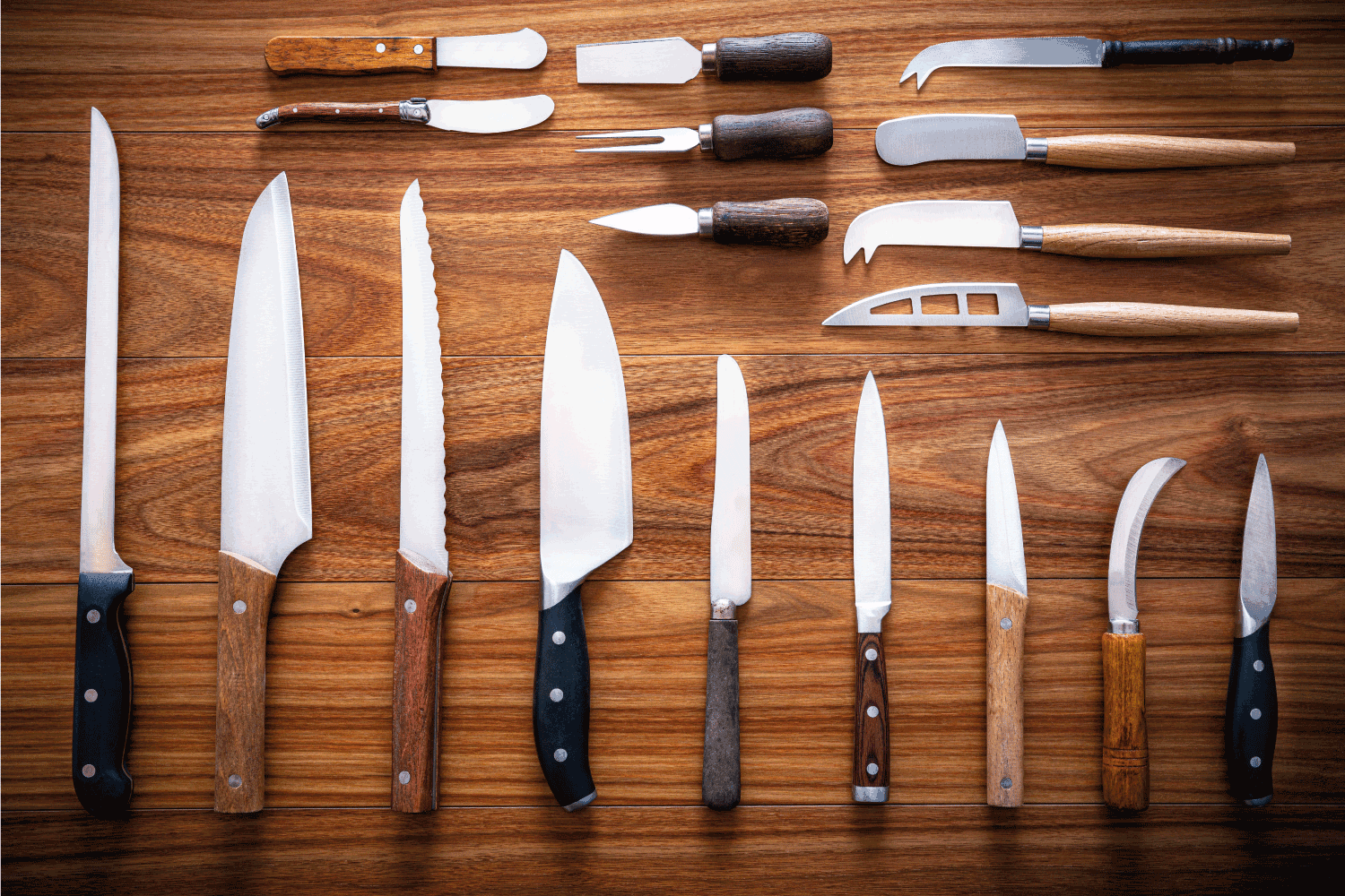Kitchen knives inventory on wooden background in a row arrangement