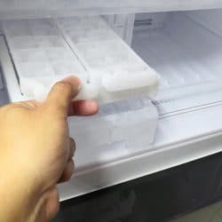 Man hand holding ice maker in new refrigerator, At What Temperature Should An Ice Maker Be On?