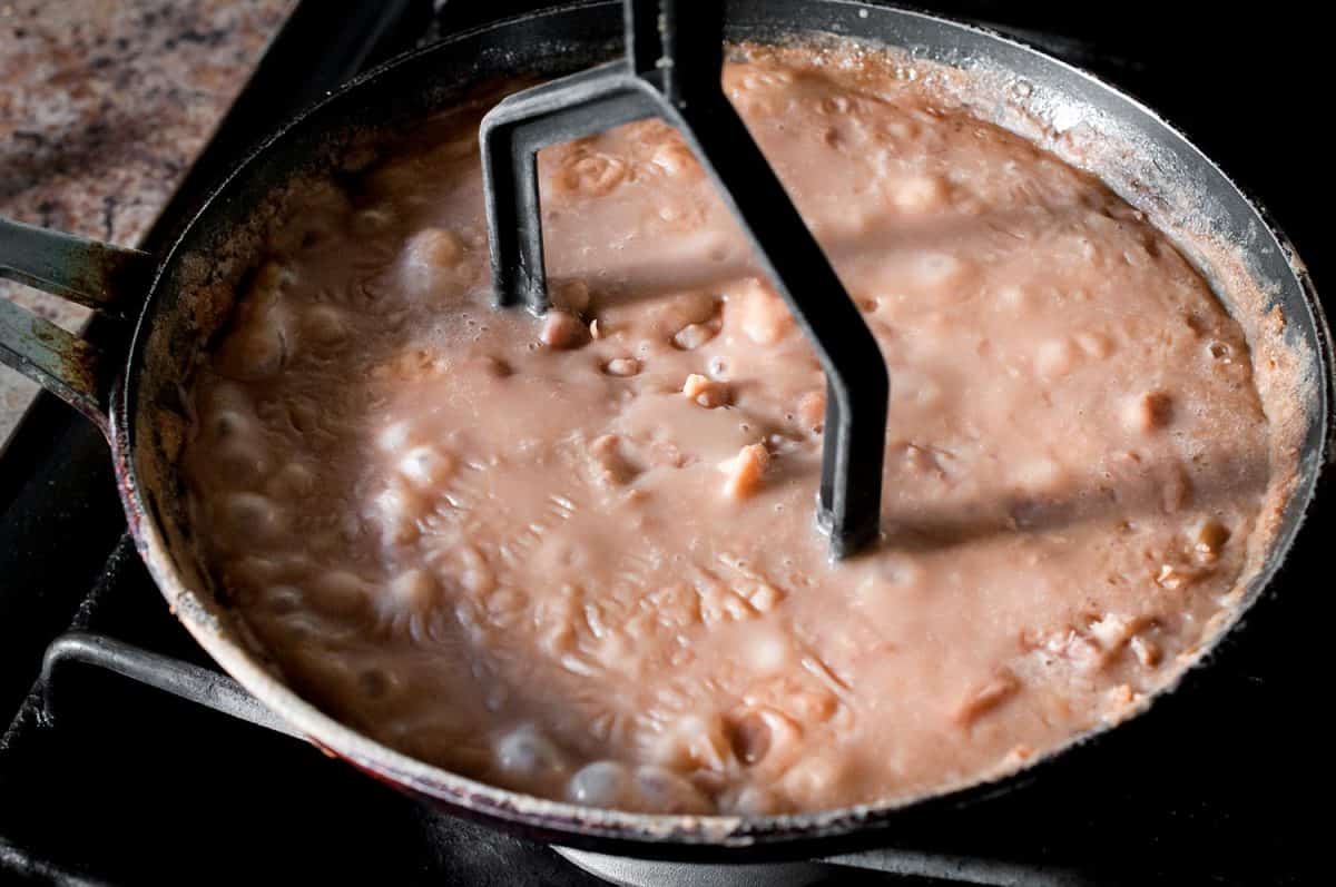 Mexican Frijoles refritos or fried beans in a cooking pan