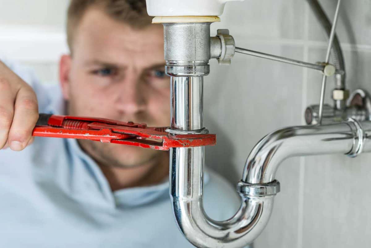 Plumber repairing kitchen sink drain