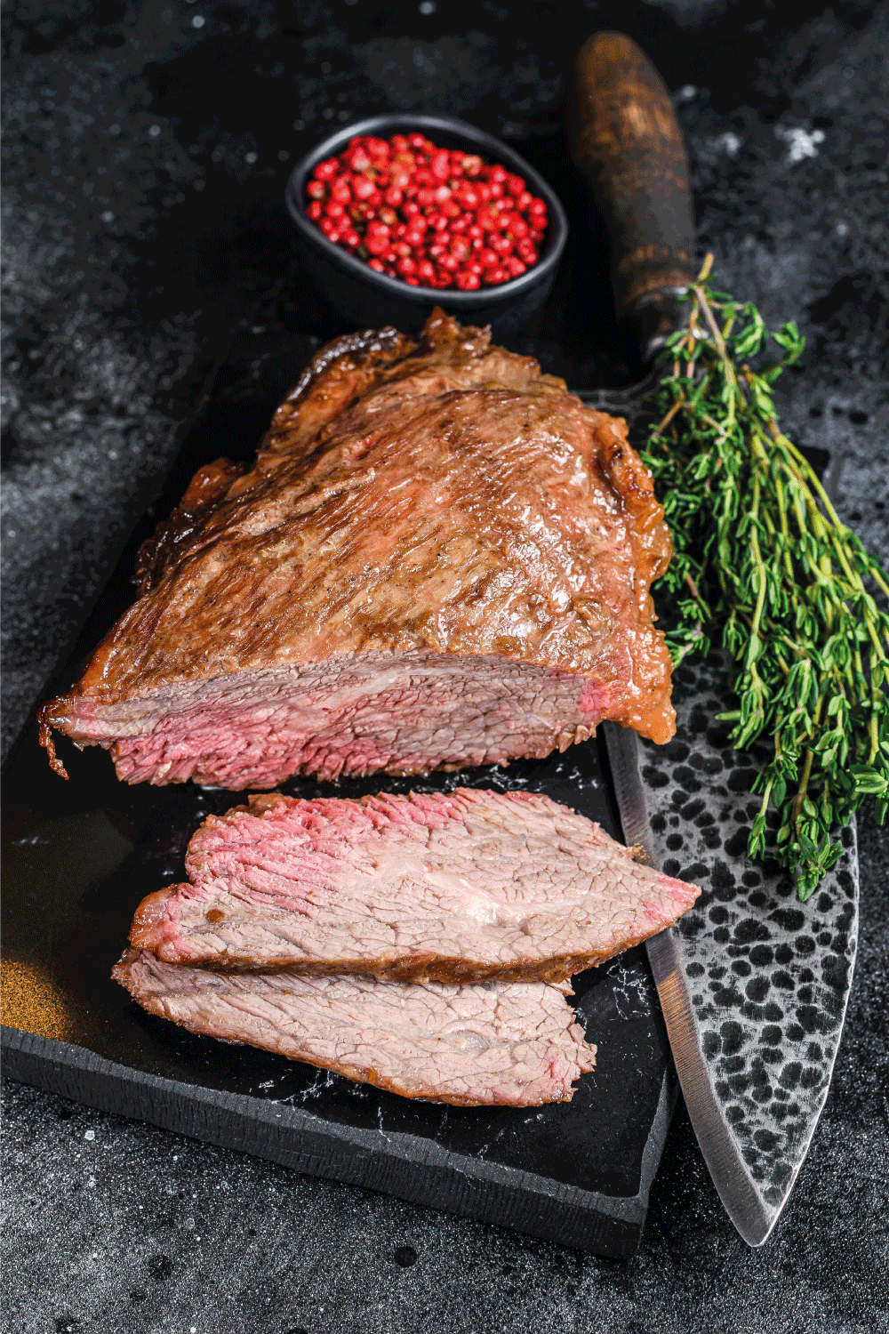 Roast beef tri tip steak bbq on granite block with knife beside it