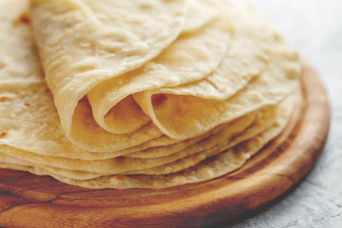 Soft uncooked homemade tortillas on a chopping board