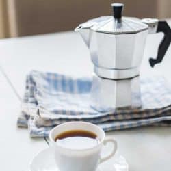Stainless steel coffee percolator and a cup of coffee on the table, How To Clean A Stainless Steel Coffee Percolator
