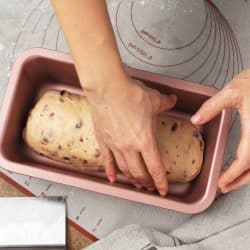 Woman hand preparing cranberry bread dough in pink loaf pan, 16 Types And Sizes Of Loaf Pans To Know