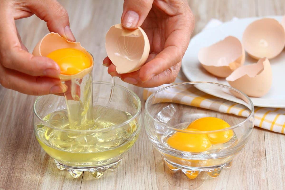 Woman breaking egg to separate egg-white and yolk