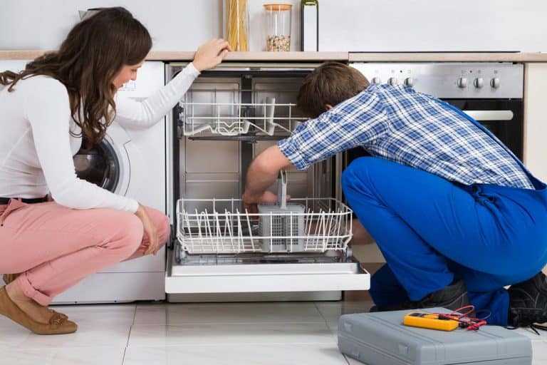 Woman looking at repairman repairing the dishwasher, Do Dishwashers Break If Not Used?