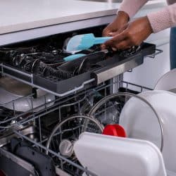 Woman unloading dishwasher after washing, How To Secure A Dishwasher To The Cabinet