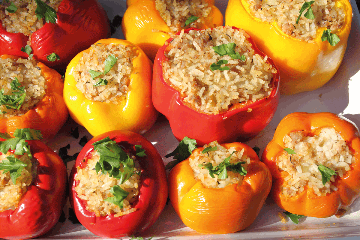 bright stuffed peppers on a ceramic tray. How Long To Cook Stuffed Peppers