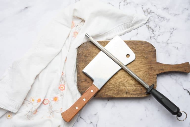 knife and old iron sharpener with handle for kitchen knives on a white background, Do Knife Sharpeners Wear Out? [And When To Replace Yours]