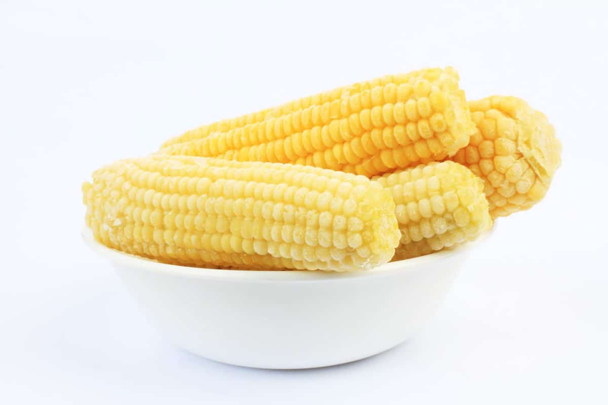 A bowl of full of peeled corn cobs