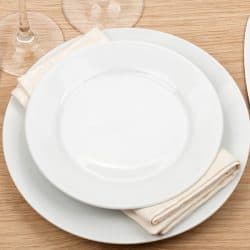 Empty plate, glasses and silverware set on wooden table, Do Corelle Dishes Break Easily?