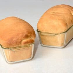 Beautifuly baken bread loafs with golden tops in glass loaf pan, Can You Bake Bread In A Glass Loaf Pan? Does It Take Longer?