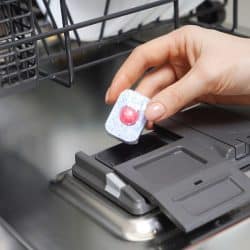 Putting a dishwasher tablet into the dishwasher machine, Should You Unwrap Dishwasher Tablets?