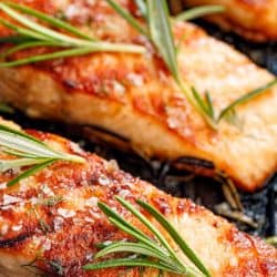 Salmon fillets sprinkled with fresh herbs and lemon juice on a grill plate, Should You Fry Or Bake Salmon?