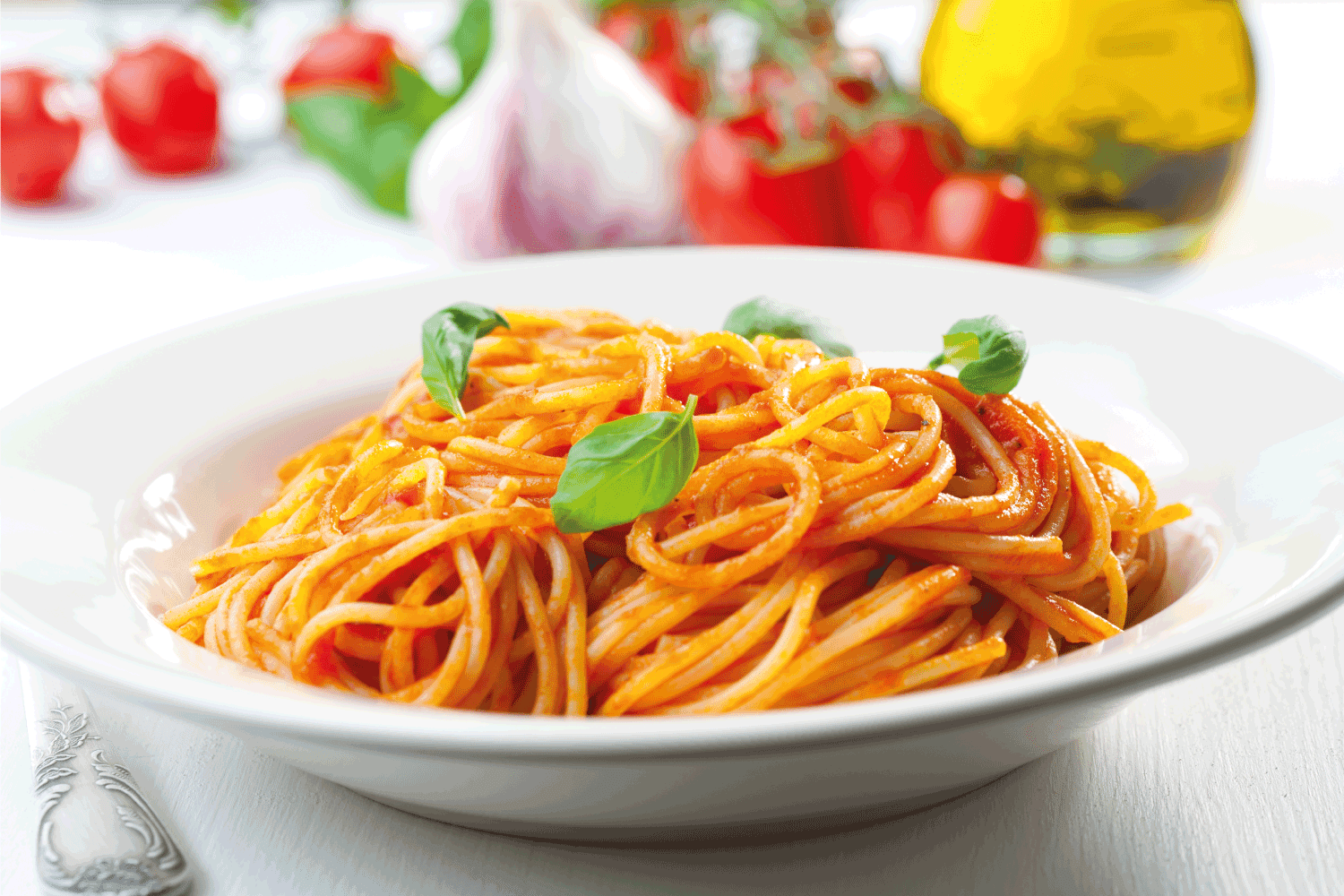 Spaghetti, tomato and basil in a white plate