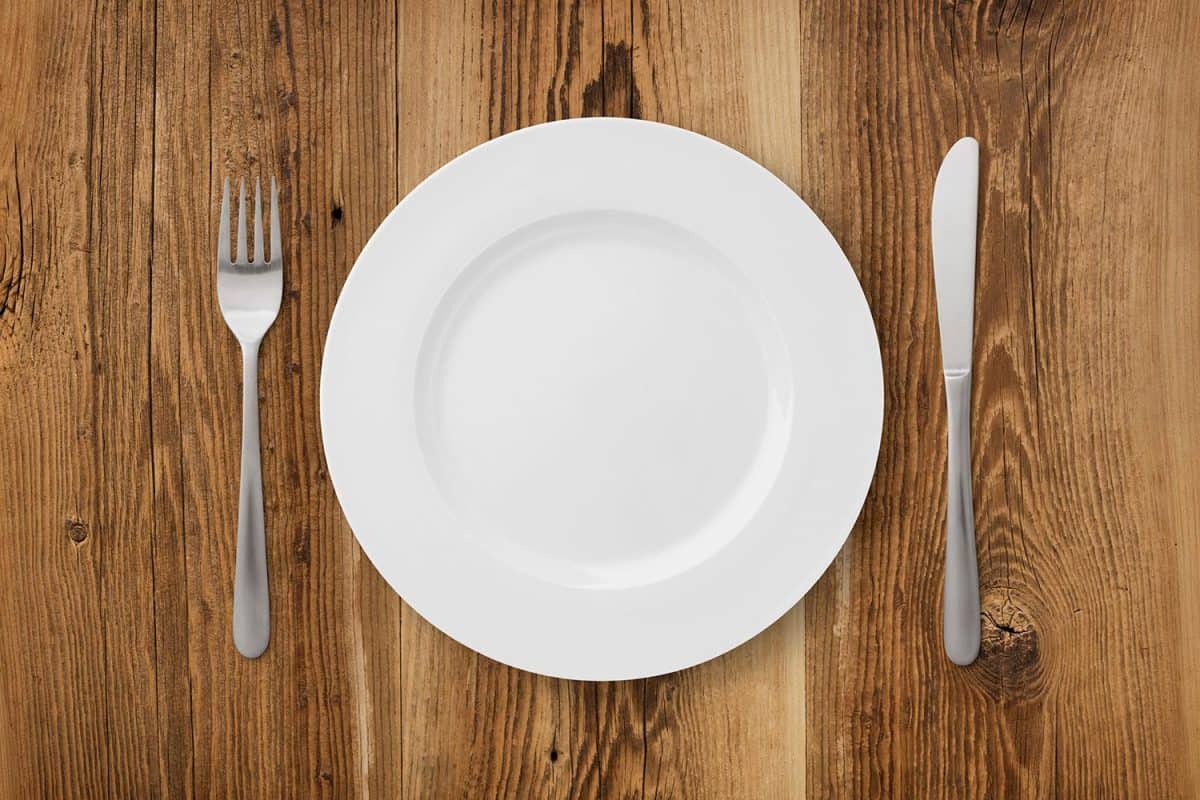 Table setting on rustic wood with plate, fork and knife