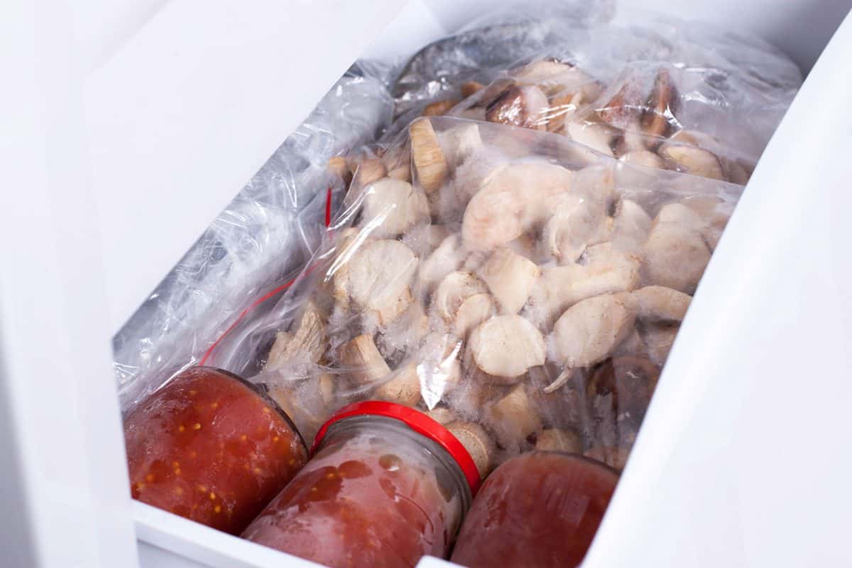 A bag of mushrooms and jams inside a deep freezer