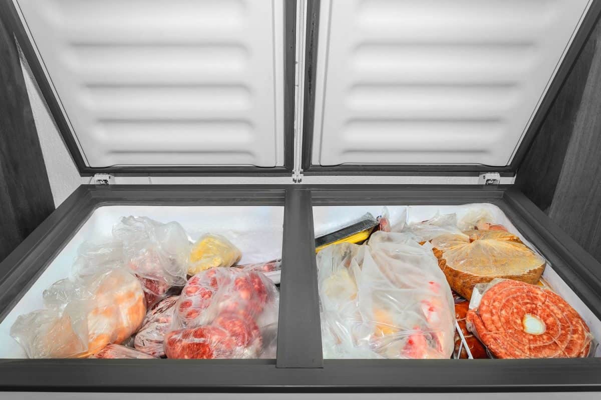 A deep freezer with lots of meat and other contained food