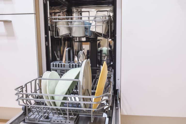 A dishwasher left open containing lots of plates and cups, How To Fix An Amana Dishwasher Door Latch In 4 Steps
