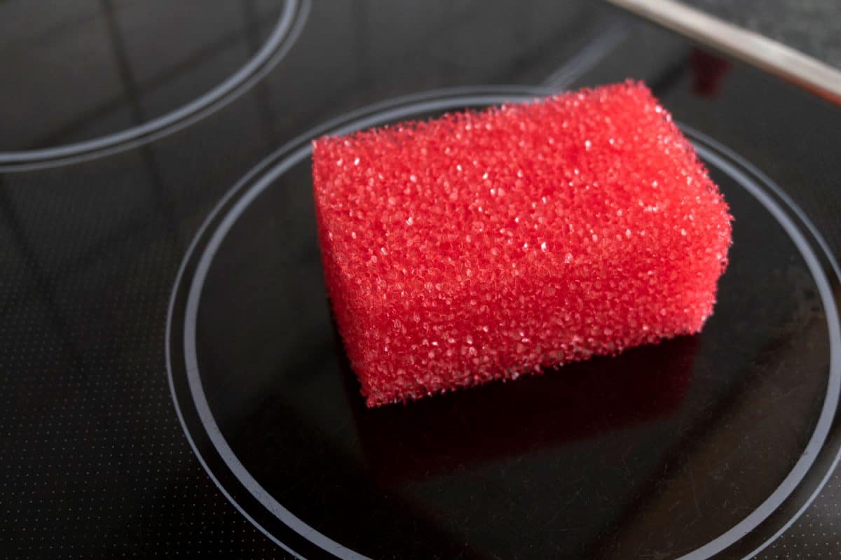 A durable high quality red sponge used for cleaning a glass top stove