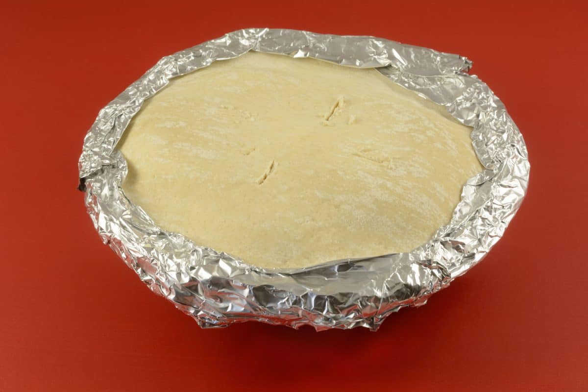 A frozen apple pie wrapped in tin foil