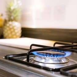 A gas stove turned on for cooking dinner, What's The Best Type Of Pots And Pans For Cooking On A Gas Stove?