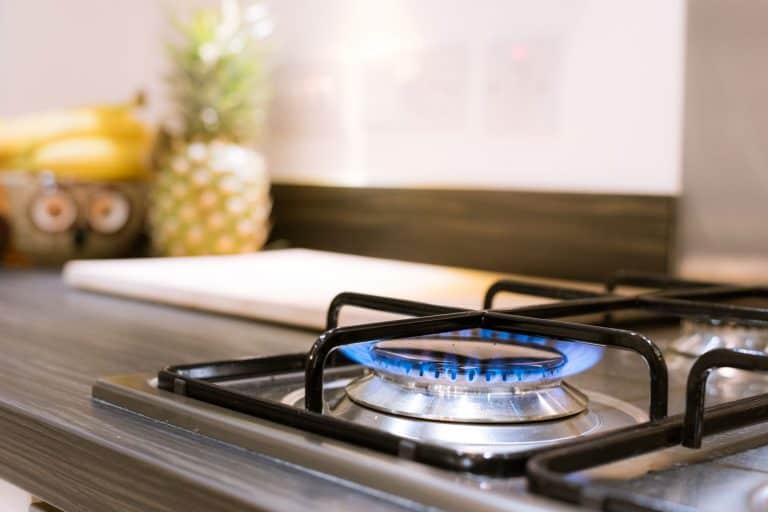 A gas stove turned on for cooking dinner, What's The Best Type Of Pots And Pans For Cooking On A Gas Stove?