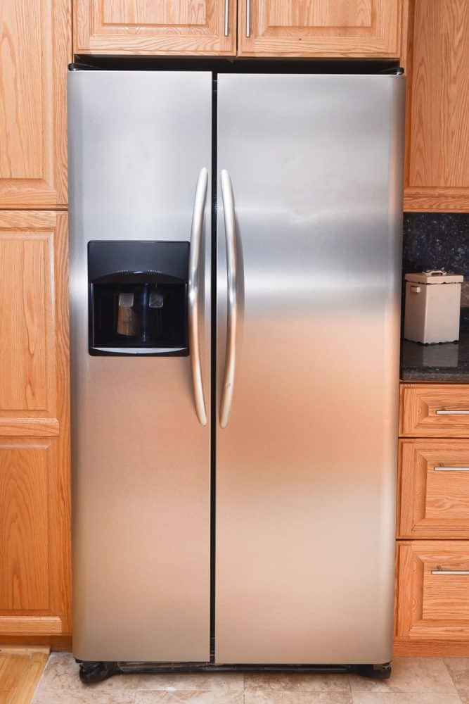 A modern double door American refrigerator with a small dispenser on the side