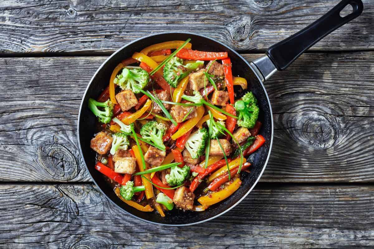 A small skillet with sueted vegetables and tofu